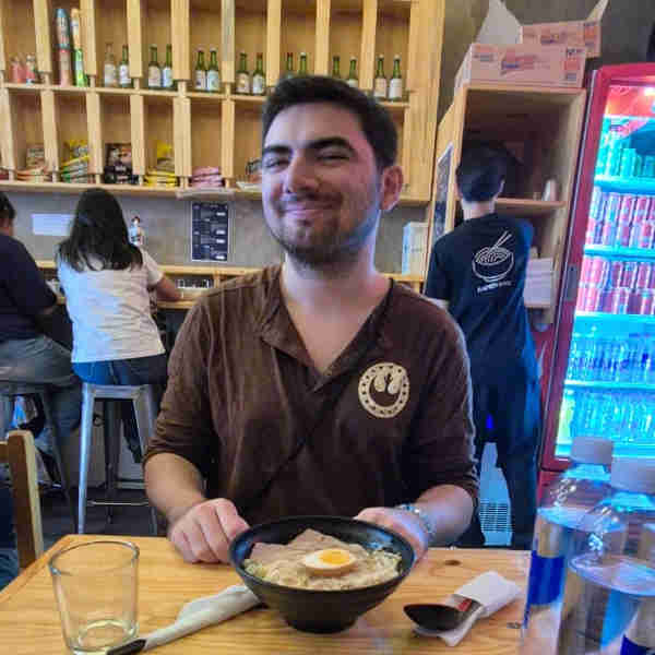 Foto de Franco Scalamandré estudiante de Diseño de Imagen y sonido sentado frente un bowl de ramen
